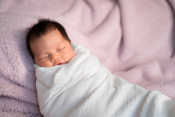 istock portrait of baby infant sleeping on soft furry bed in studio. 1295584792