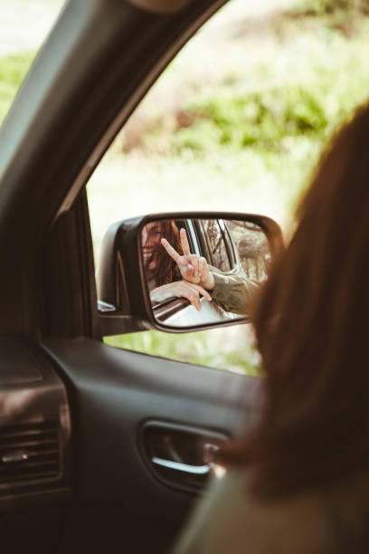 istock reflection on stunning smiling woman in car rear mirror 1295587481
