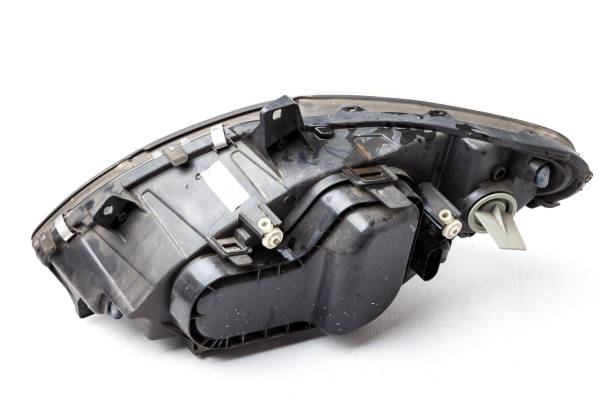 istock Spare part made of black plastic, rear view on white background in a photo studio for a catalog - a xenon headlight inside electrical systems and optical equipment assemblies of a lamp and reflectors 1295587770