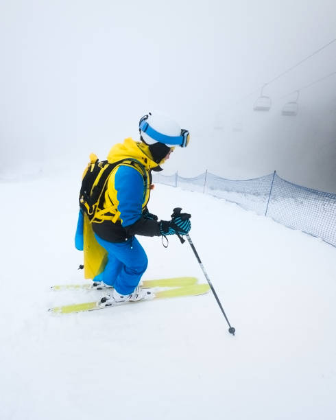 istock young woman skier sliding down by snowed slope 1295587777