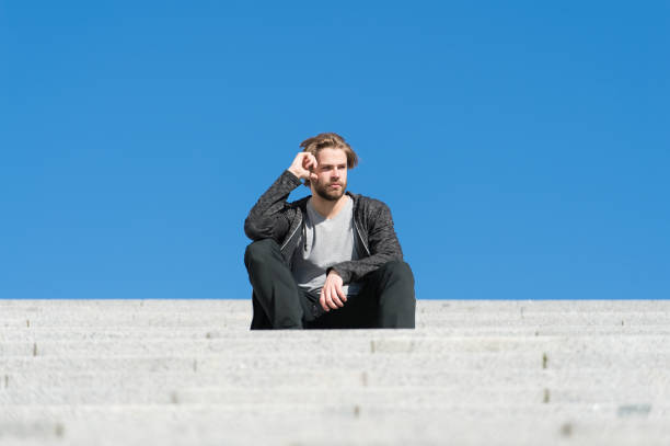 istock Macho sit on stair on sunny blue sky, perspective 1295590814