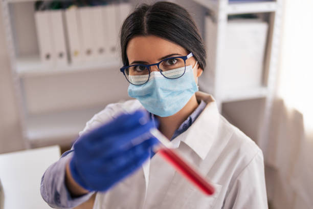 istock Coronavirus protection. Scientific researches in microbiological laboratory on COVID-19 vaccine elaboration in medical clinic. Female doctors wearing protective face masks looking at microbiology samples through a medical microscope and discussing. 1295593245