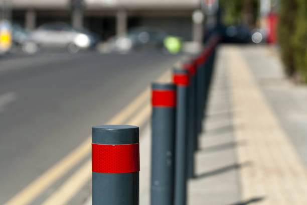 istock Row of street bollards between road and sidewalk 1295594313