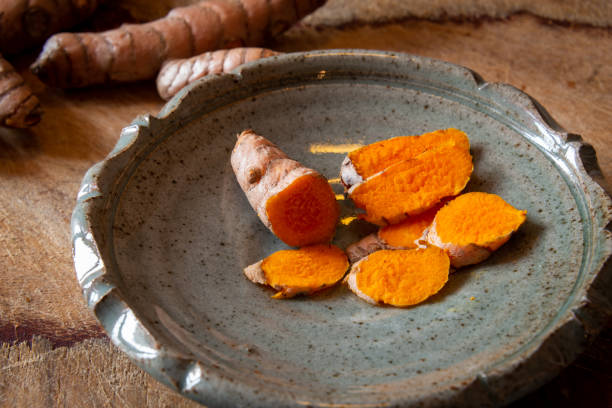 istock cut turmaric on a  blue plate on a chopping board. 1295595524