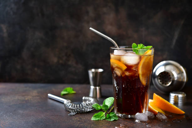 Cold summer soda cocktail with cola, dark rum and orange