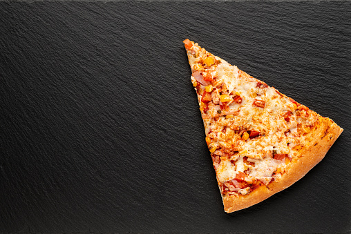 slice of pizza on slate board