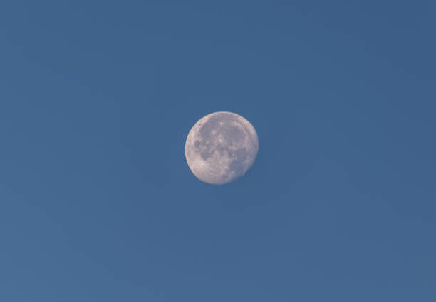 istock Full moon seen on the blue sky through camera lens 1295609541