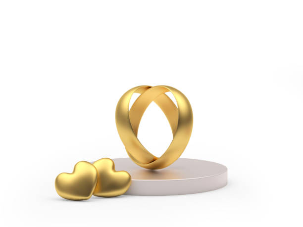 istock Gold connected wedding rings and two hearts on a round stand 1295609550
