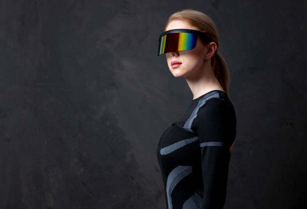 istock Blonde android female in VR glasses and suit on dark background. 1295610885
