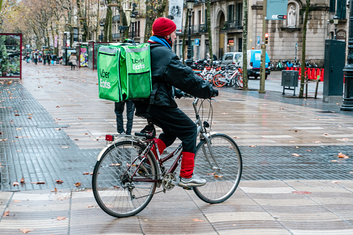 Barcelona, Spain - January 9, 2020: Man delivering food with Uber Eats service, due to isolation caused by the coronavirus outbreak.