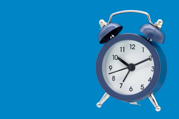 istock Classic alarm clock isolated on blue background. 1295613821