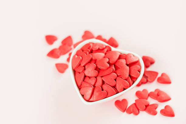 istock Heart shaped red sprinkles in a white bowl 1295614010