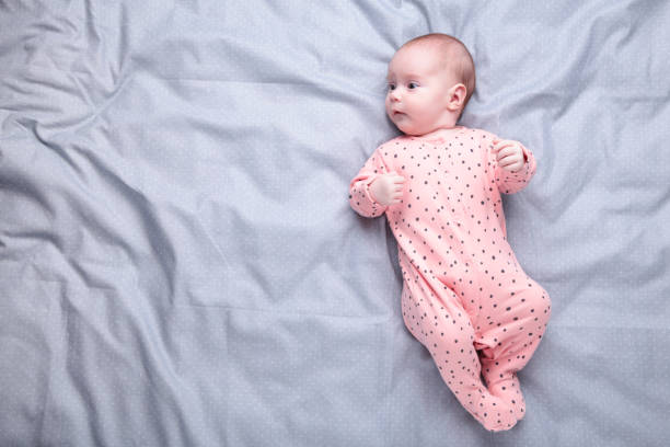 istock Cute baby on the grey bed with copy space 1295614104