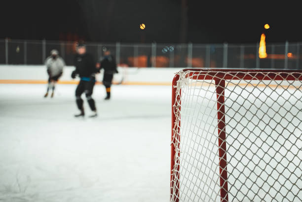 istock People play hockey outdoors in winter time. 1295615542