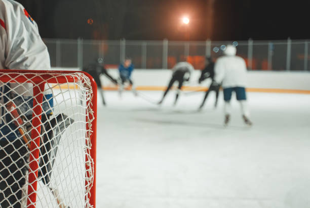 istock People play hockey outdoors in winter time. 1295615562