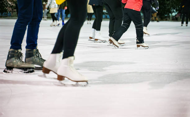 menschen eislaufen auf der eisbahn im winter. - eislaufen stock-fotos und bilder