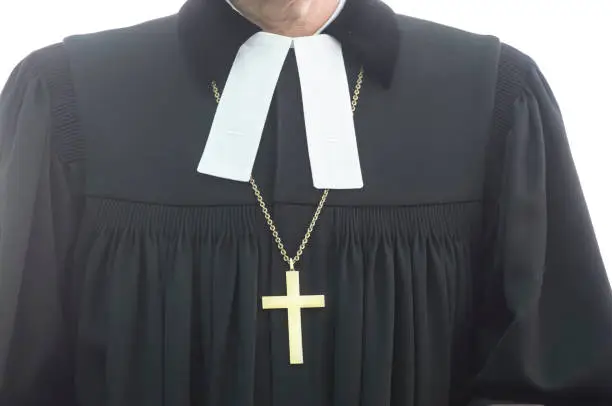 an evangelical pastor in black clothing wearing a golden cross