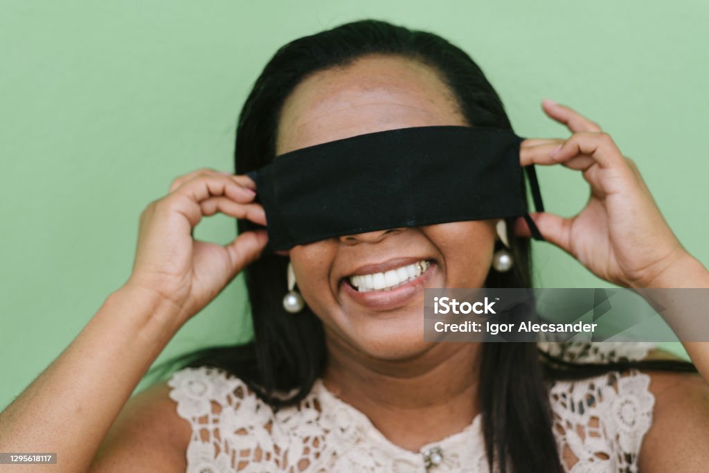 Woman putting protective mask on eyes Misinformation Stock Photo