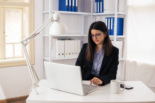 istock The New Normal. New office setup. Woman working alone in the new office space while COVID-19 pandemic. 1295618201
