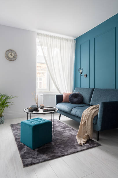 istock Stylish living room with teal blue wall 1295618681
