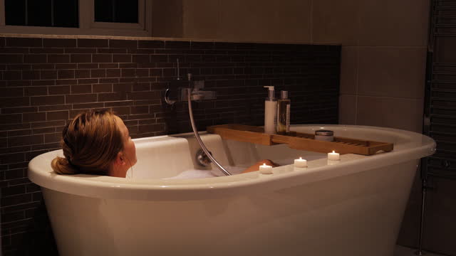 Young woman sinking in to bath, relaxing