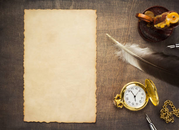 istock Romantic retro design concept at wooden background surface. Candle with parchment and ink pen at wood table 1295628552