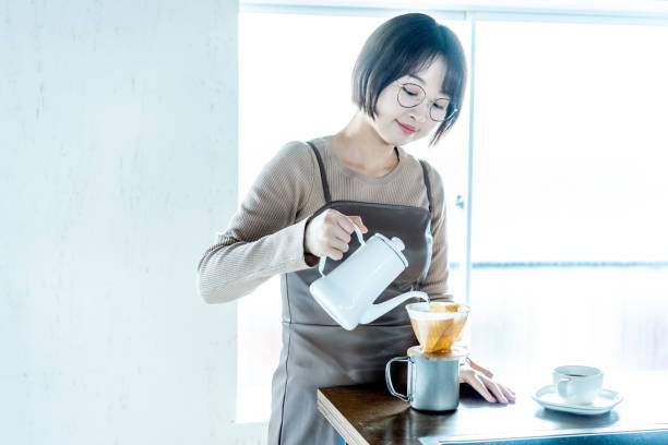 istock Woman making coffee at home 1295628587