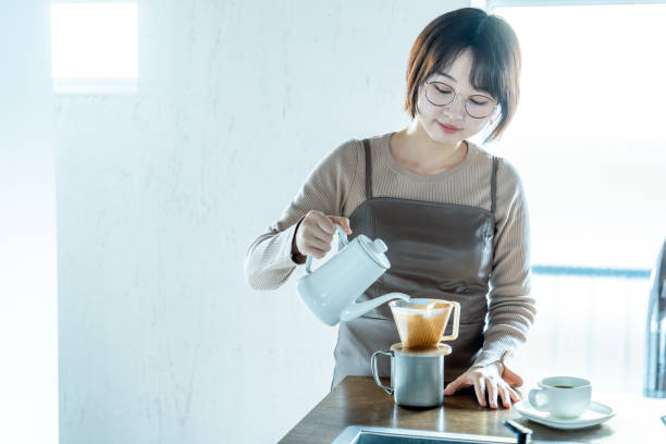 istock Woman making coffee at home 1295628605