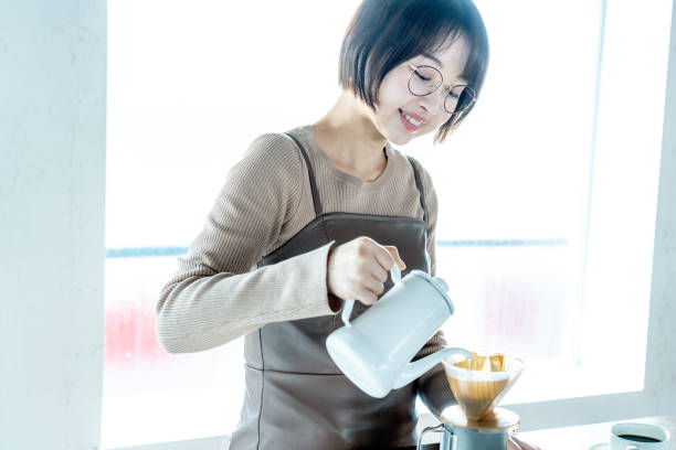 自宅でコーヒーを飲む女性 - 温かい飲み物 ストックフォトと画像