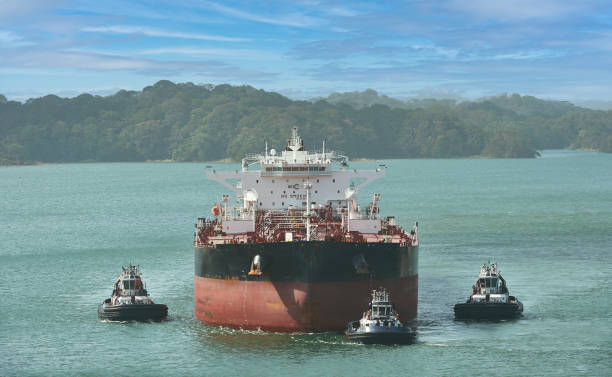 Cargo boat escorted by tug boats