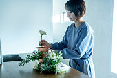 自宅で花を飾る女性
