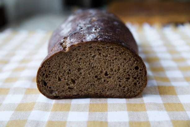 Homemade rye bread in a cut on a light background on a yellow towel, close-up
