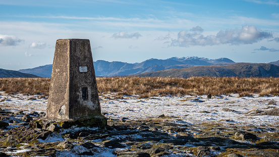 Cumbria, England - November 10, 2019: The summit trig point on High Street, a mountain / fell in the Lake District, Cumbria, England.