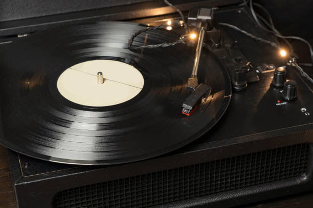 istock Vintage old retro vinyl electronic record player with black record 1295636831