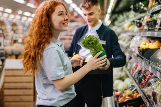 istock Young workers packing fresh produce on the shelves 1295641643