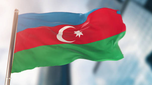 nationalflagge von aserbaidschan gegen defokussierte stadtbauten - azerbaijan flag stock-fotos und bilder