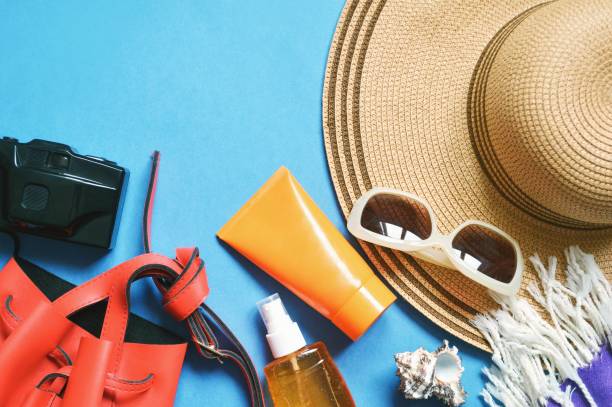 istock Flat lay summer still life photography. Top view beach essentials. Red bag, camera, sunscreen cream, sunglasses and sun hat 1295644416