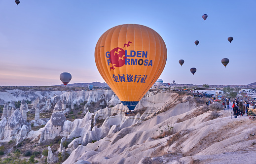 Goreme, Turkey - October  25, 2020: Colorful hot air balloons flying early in the morning over the valley at Cappadocia, Nevsehir, Turkey.