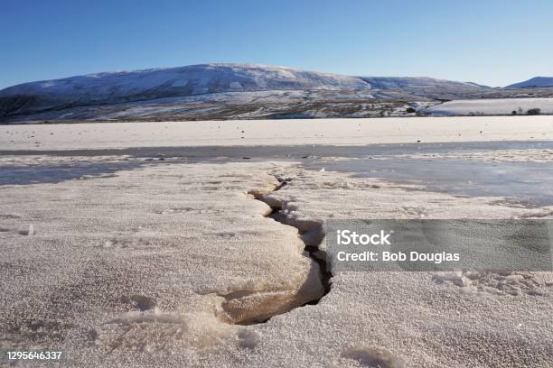 얼어붙은 저수지 옆에 금이 간 얼음 0명에 대한 스톡 사진 및 기타 이미지 - 0명, 겨울, 경관 - iStock