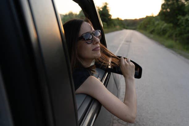 istock Young woman looking through window while riding in car in nature 1295646590