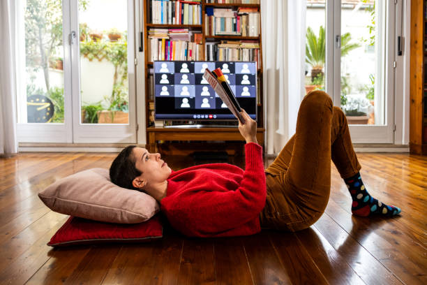 istock Woman relaxing reading a magazine before going on live streaming video conference 1295647710