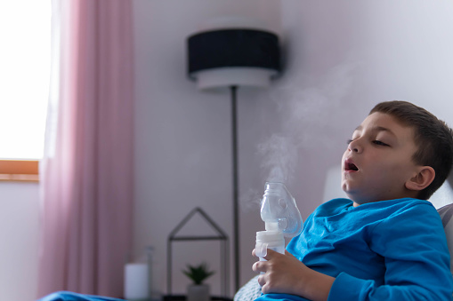 Sick child makes himself inhalation mask for breathing in his room