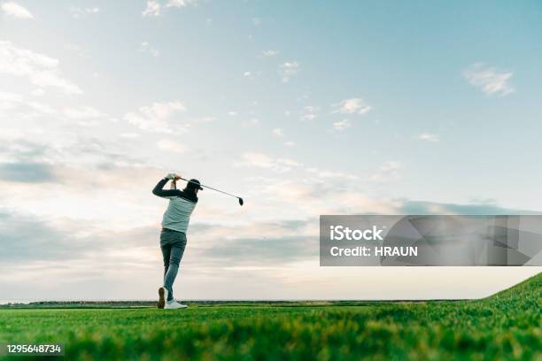 Male Golfer Swinging Club At Course During Sunset Stock Photo - Download Image Now - Golf, Golf Course, Golfer