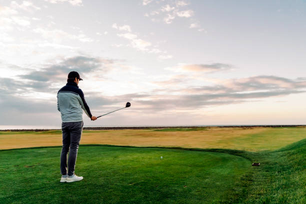 istock Male athlete playing golf at course during sunset 1295648771