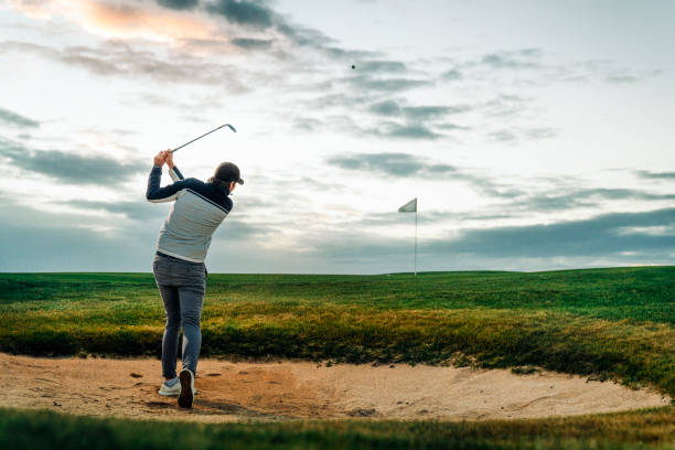 istock Male golfer hitting golf ball from sand trap 1295649080