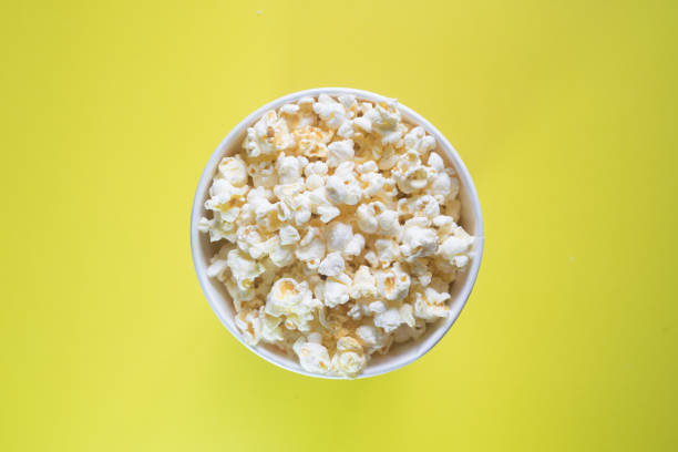 istock Popcorn viewed from above on yellow background. 1295650517