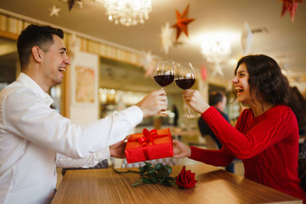 istock Young couple having a romantic dinner and toasting with cups of red wine. 1295651665