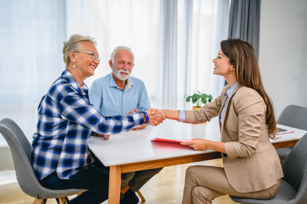 istock Senior couple shaking hands with financial advisor 1295654028