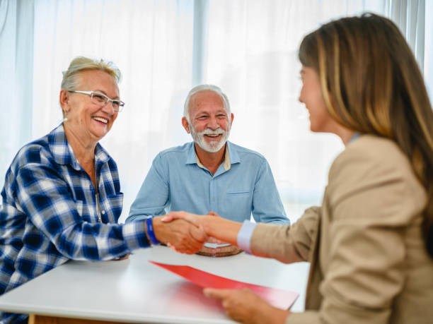 istock Senior couple shaking hands with financial advisor 1295654211