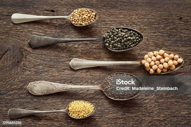 Millet Chia Chickpeas Buckwheat And Lentils On Five Vintage Spoons Stock Photo - Download Image Now